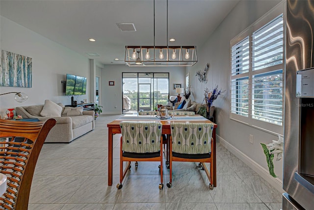 tiled dining space with an inviting chandelier