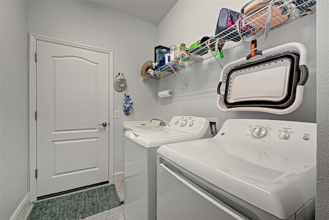 washroom with sink, light tile floors, hookup for a washing machine, and washer and clothes dryer