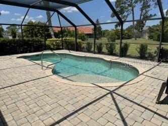 view of pool with a lanai and a patio