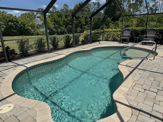 view of swimming pool featuring a patio area and glass enclosure