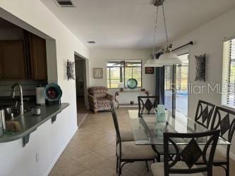 dining area with light tile patterned flooring, a wealth of natural light, and sink