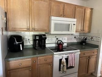 kitchen with white appliances and backsplash