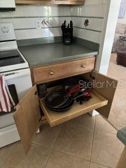 room details featuring white range with electric stovetop and tasteful backsplash