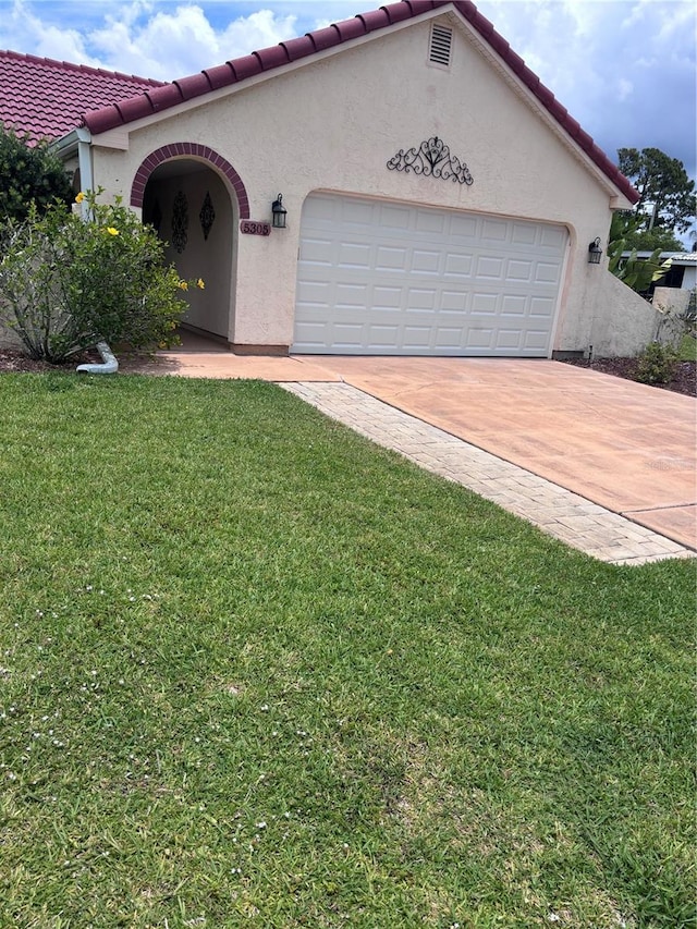 mediterranean / spanish-style house with a front yard and a garage