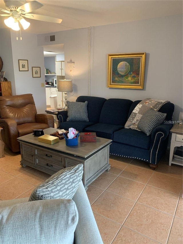 living area with a ceiling fan, visible vents, and light tile patterned floors