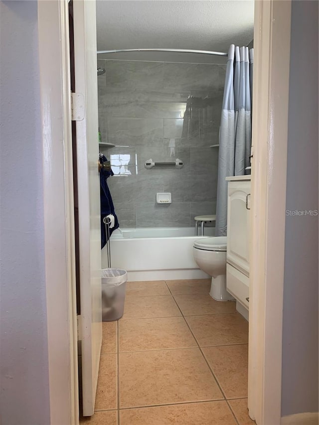 bathroom featuring shower / bath combo with shower curtain, vanity, toilet, and tile patterned floors