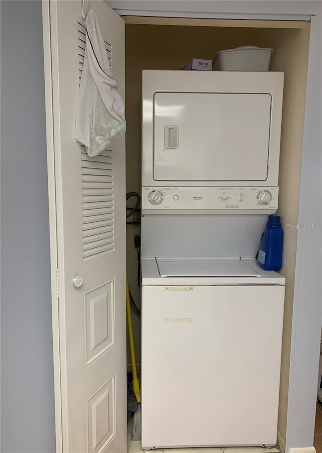 clothes washing area with stacked washer and dryer and laundry area