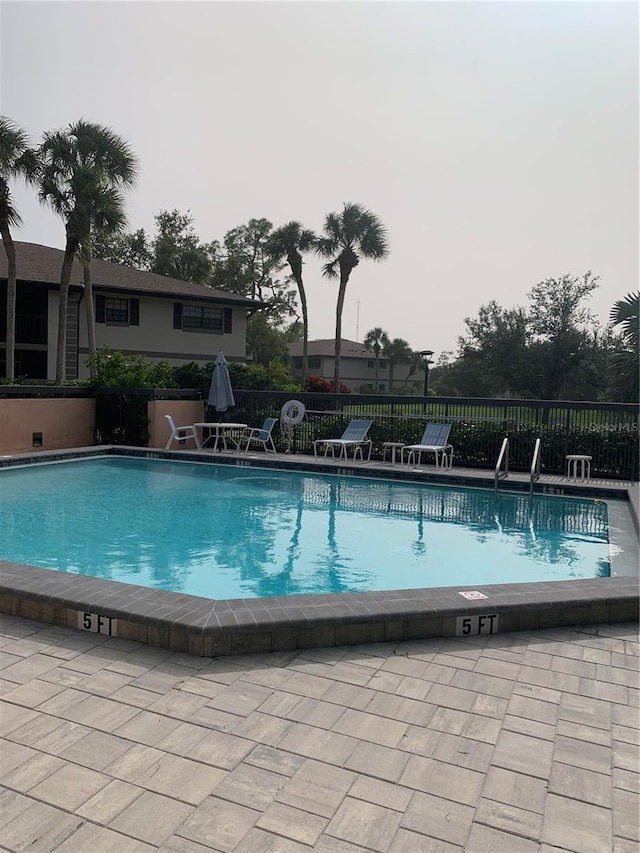 pool featuring a patio area and fence