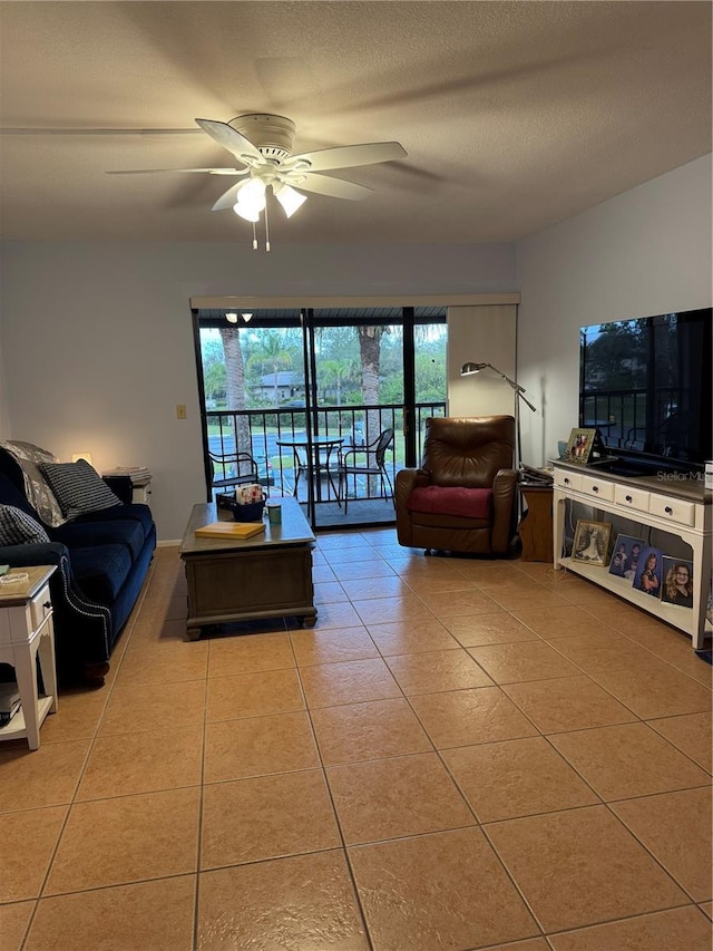 living area featuring a ceiling fan, a textured ceiling, and tile patterned floors