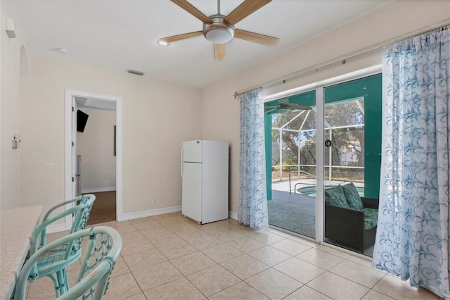 tiled spare room featuring ceiling fan