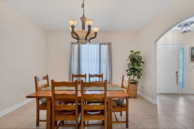 dining area with a chandelier and light tile flooring