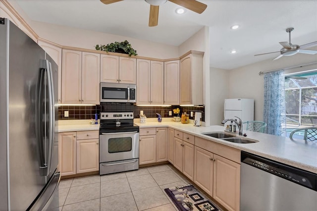 kitchen featuring ceiling fan, light tile floors, sink, tasteful backsplash, and stainless steel appliances