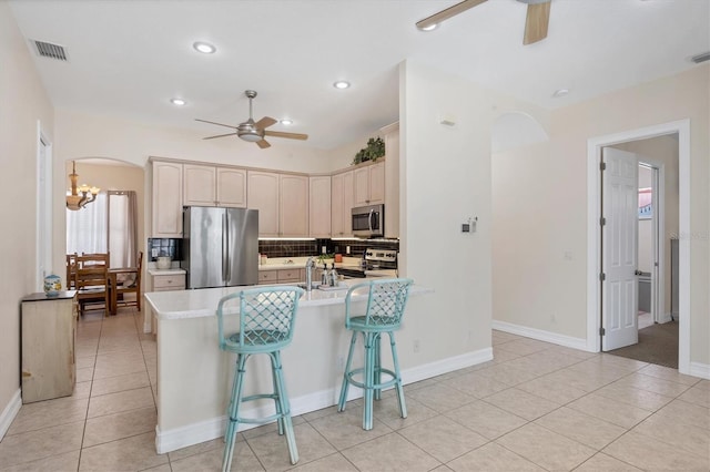 kitchen featuring light tile flooring, ceiling fan, tasteful backsplash, and stainless steel appliances