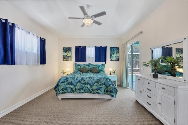 bedroom with a tray ceiling, ceiling fan, and carpet