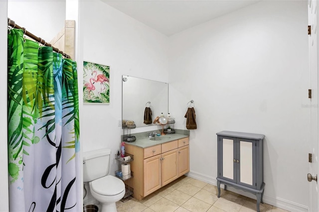 bathroom featuring tile floors, vanity with extensive cabinet space, and toilet