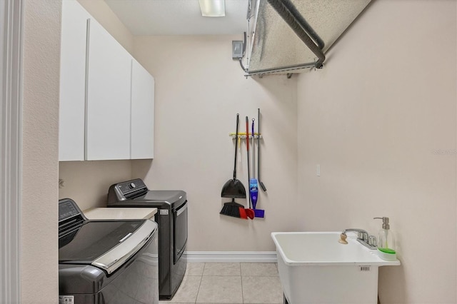 laundry room with light tile floors, cabinets, sink, and washer and dryer