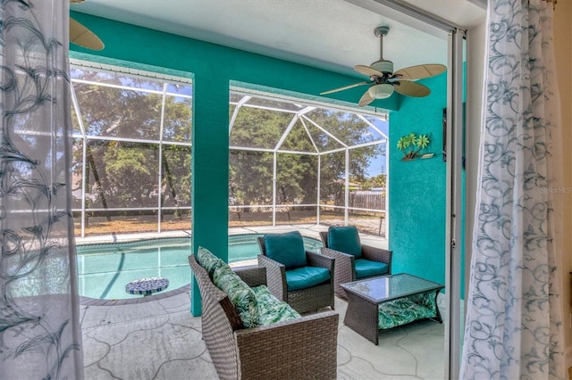 view of swimming pool featuring a patio area, ceiling fan, and glass enclosure