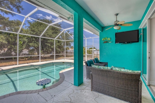 view of pool with a patio, glass enclosure, ceiling fan, and an outdoor hangout area