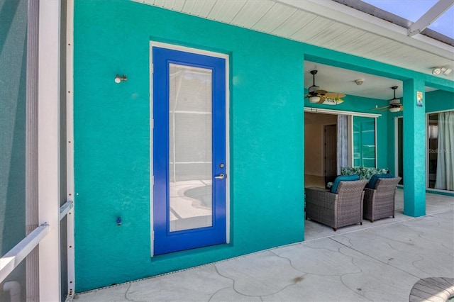 entrance to property with a patio area and ceiling fan