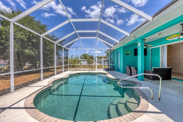 view of swimming pool featuring glass enclosure, ceiling fan, and a patio area