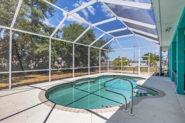 view of pool with glass enclosure and a patio