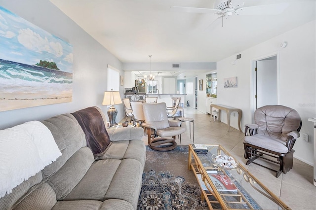 living room featuring ceiling fan with notable chandelier and tile floors