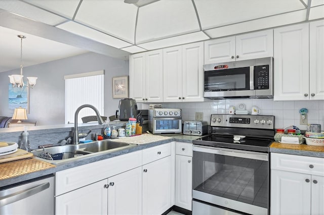 kitchen with backsplash, sink, stainless steel appliances, and white cabinetry