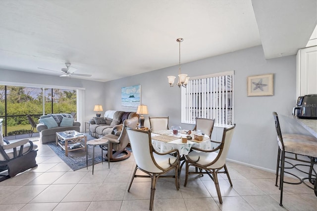 tiled dining space with ceiling fan with notable chandelier