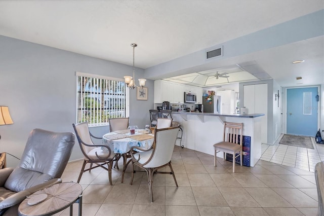 dining area with ceiling fan with notable chandelier and light tile floors