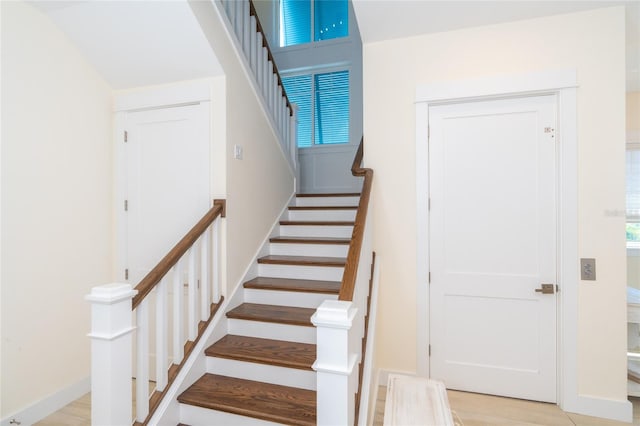 stairway with light hardwood / wood-style flooring