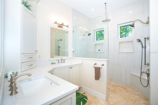 bathroom with vanity with extensive cabinet space, a tile shower, and tile flooring