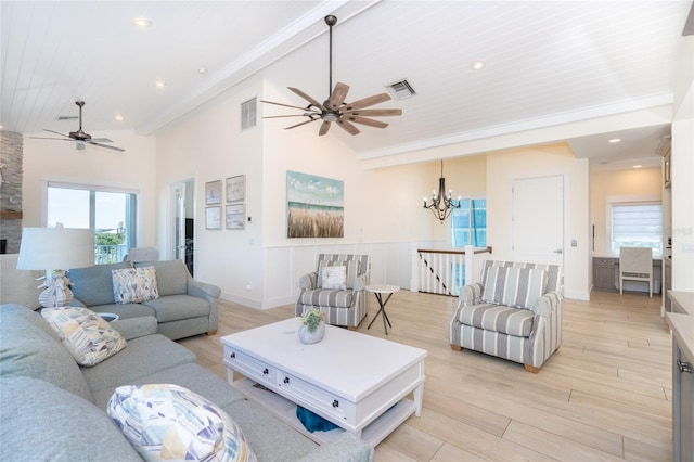 living room with high vaulted ceiling, light hardwood / wood-style floors, and ceiling fan with notable chandelier