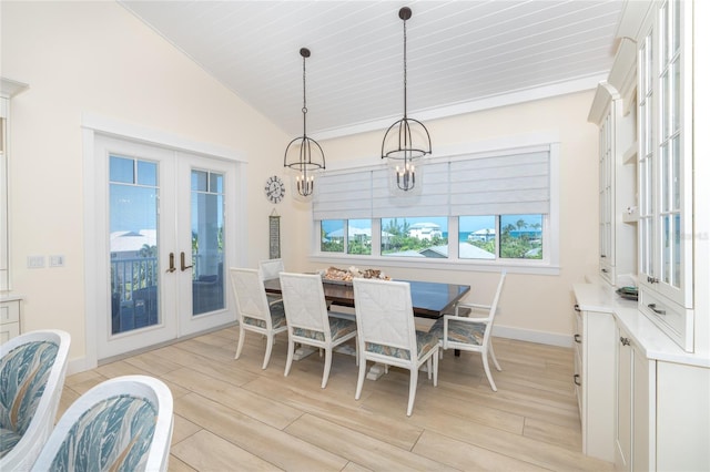 dining room with french doors, light hardwood / wood-style flooring, and vaulted ceiling