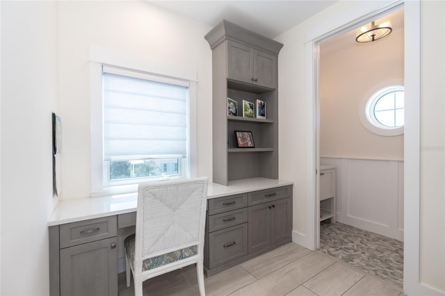 tiled office with a healthy amount of sunlight and built in desk