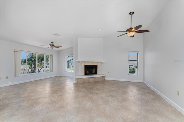 unfurnished living room with high vaulted ceiling, a tiled fireplace, ceiling fan, and light tile floors