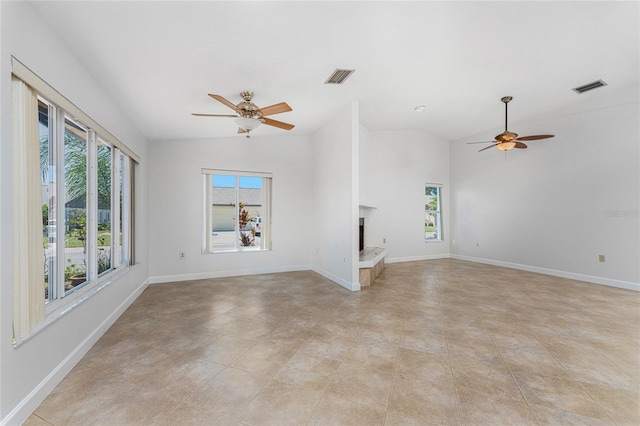 unfurnished living room featuring light tile flooring, ceiling fan, and a healthy amount of sunlight