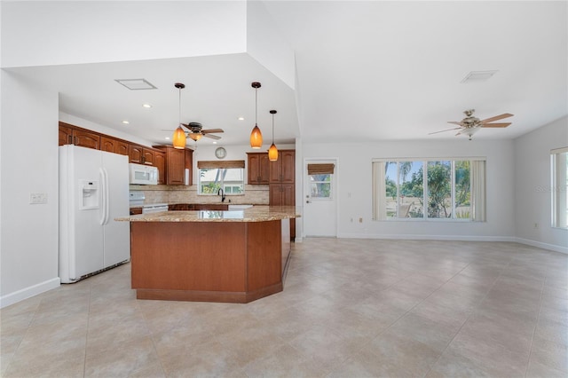 kitchen featuring plenty of natural light, a kitchen island, white appliances, ceiling fan, and tasteful backsplash