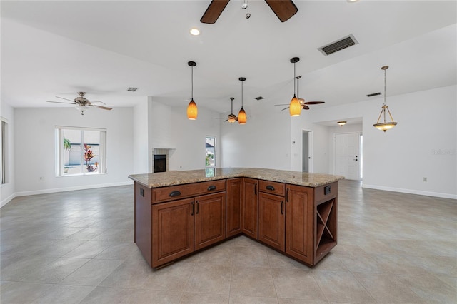 kitchen featuring plenty of natural light, light stone countertops, hanging light fixtures, and light tile flooring