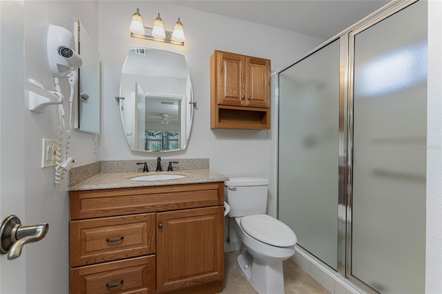 bathroom with a shower with door, vanity, toilet, and tile flooring