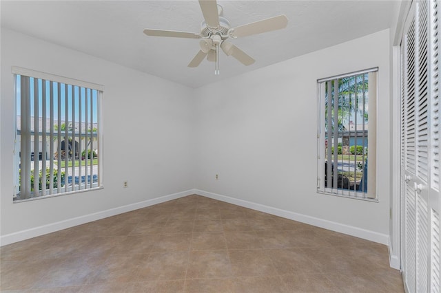 tiled spare room with a healthy amount of sunlight and ceiling fan