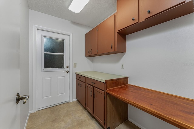 kitchen featuring a textured ceiling and light tile floors