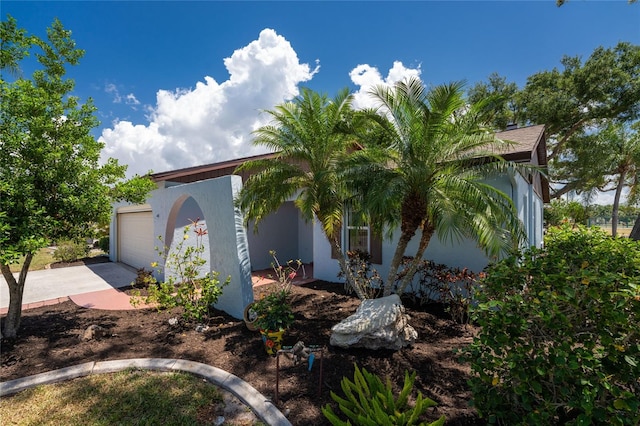 view of front of property featuring an attached garage, driveway, and stucco siding