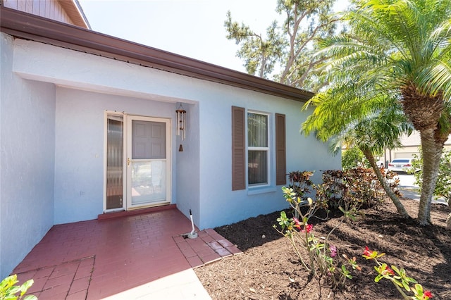 entrance to property featuring stucco siding