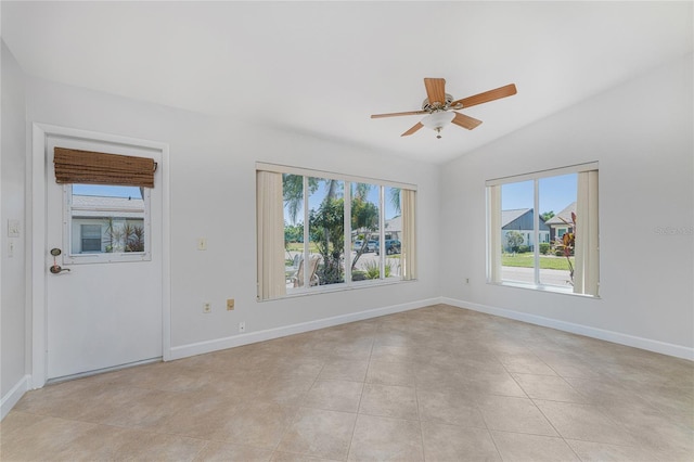 spare room with vaulted ceiling, light tile patterned floors, a ceiling fan, and baseboards