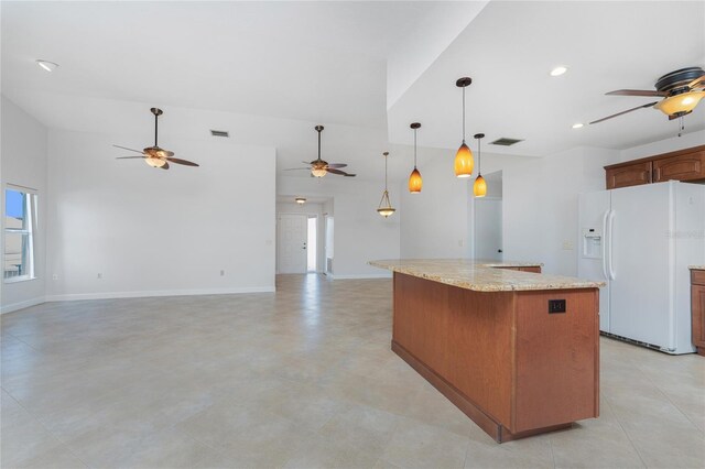 kitchen featuring white refrigerator with ice dispenser, visible vents, a kitchen island, light stone counters, and pendant lighting