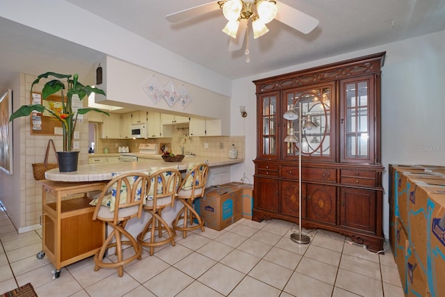 foyer featuring ceiling fan and light tile flooring