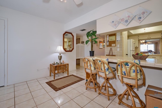 dining area with ceiling fan and light tile floors