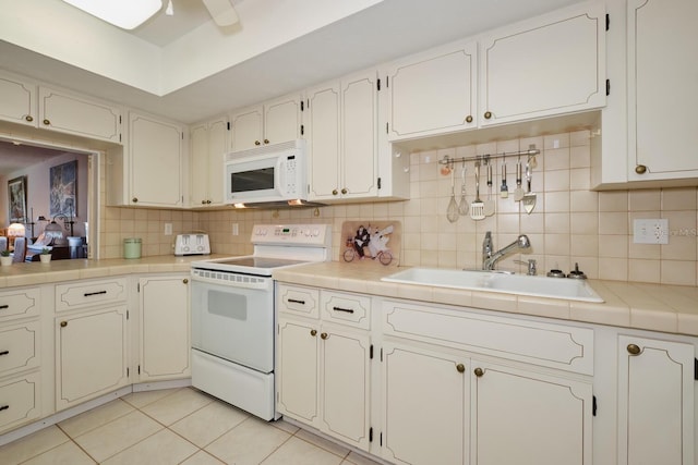 kitchen with white cabinets, white appliances, sink, tasteful backsplash, and tile countertops