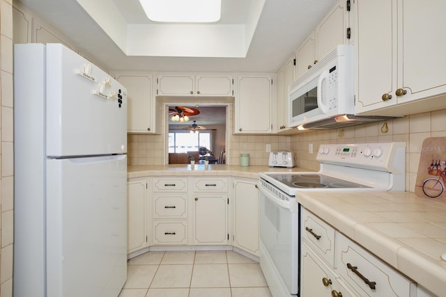 kitchen featuring white cabinets, white appliances, tasteful backsplash, and light tile floors