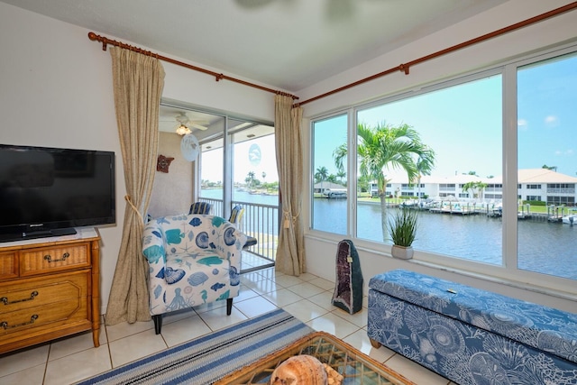 tiled living room featuring a water view and ceiling fan